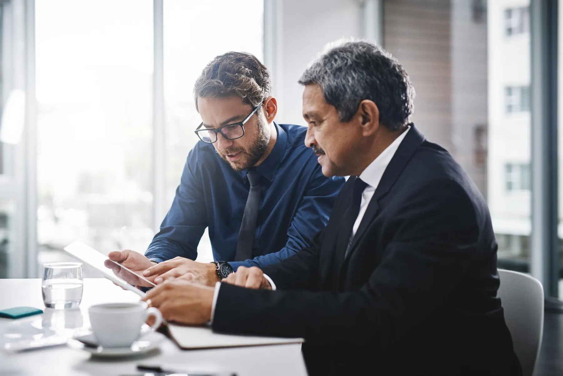 Two colleagues reviewing product data on a tablet