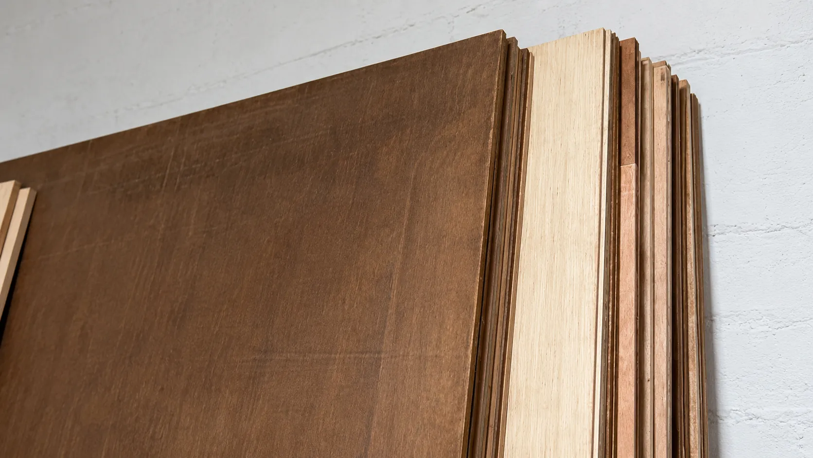 Close-up of stacked engineered wood panels with a dark veneer face